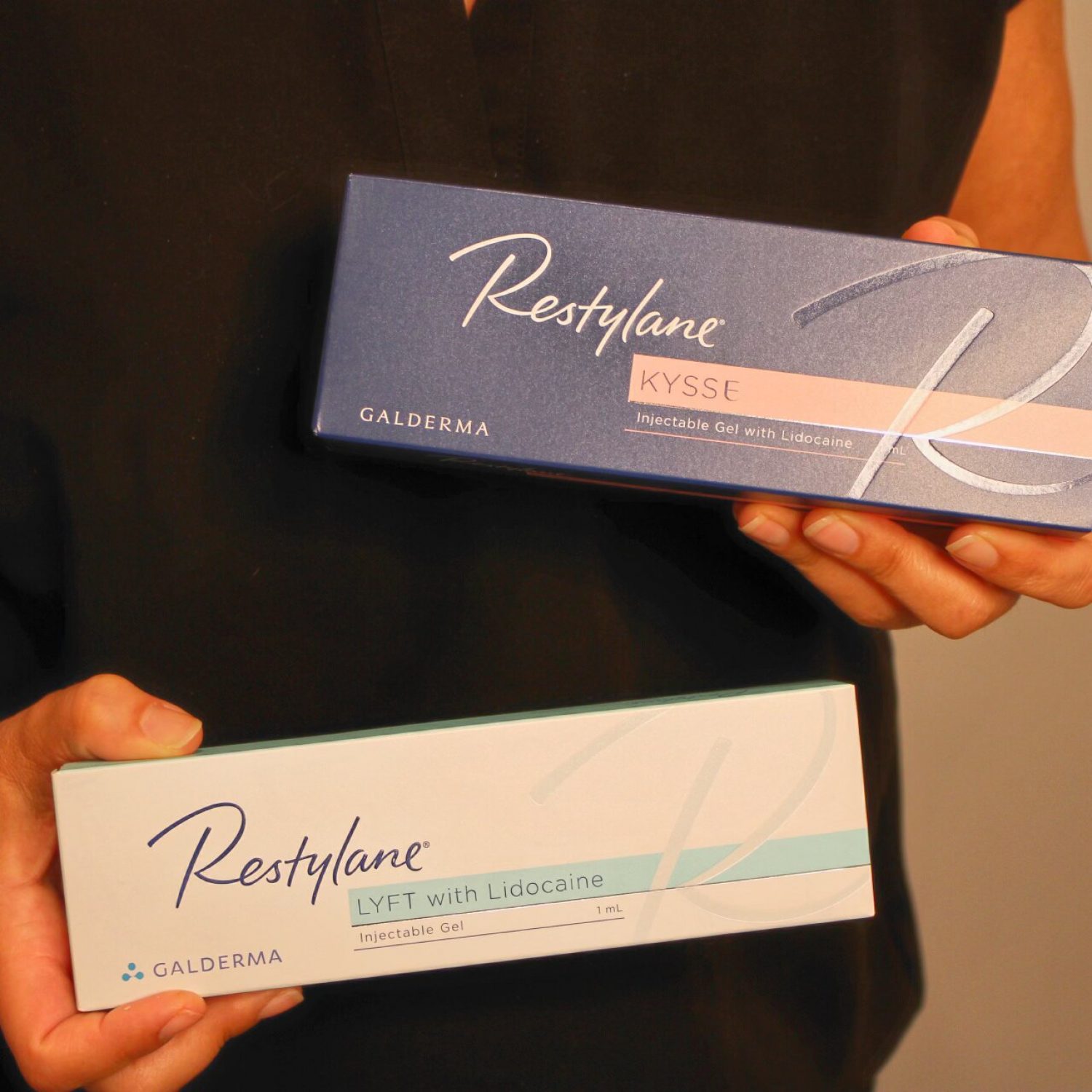 women displaying two syringes of retsylane kysse for the lips and restylane lyft with lidocaine to improve skin rejuvenation and volume